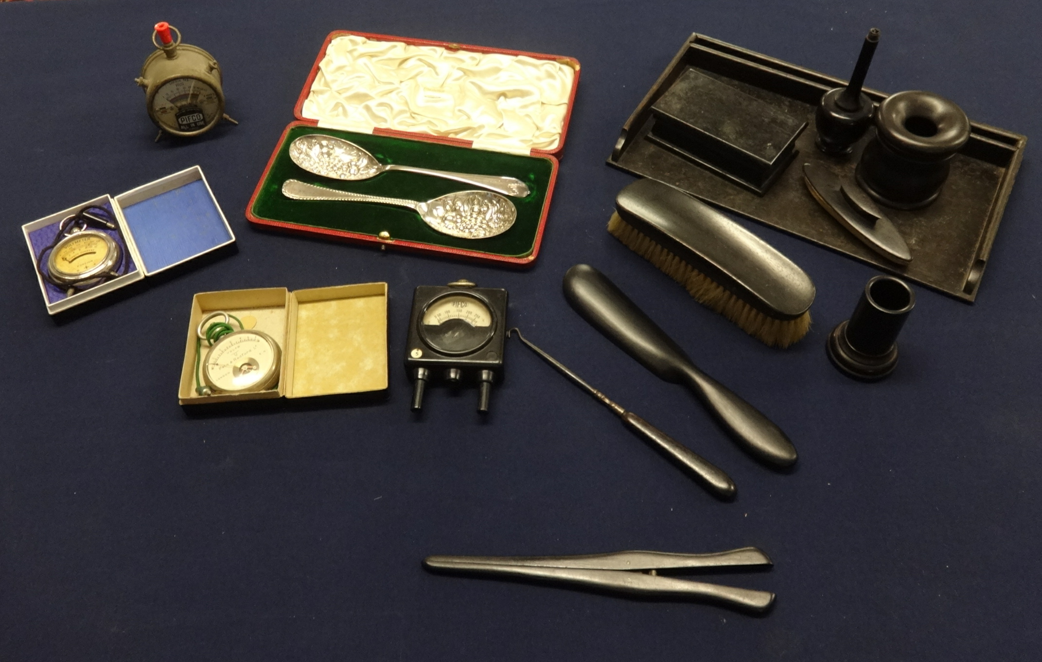 A pair of silver plated berry spoons cased, volt amp meters and ebony ten piece dressing table set.