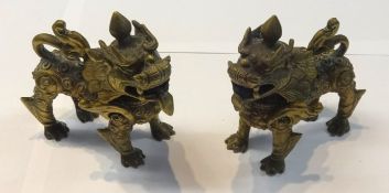 A pair of gilt possibly bronze Chinese dogs, height 10cm.