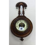 An early 20th century small carved walnut barometer.