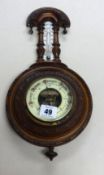An early 20th century small carved walnut barometer.