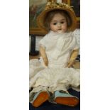 An early 20th century bisque headed doll, with composition body, open/sleep eyes and open mouth,