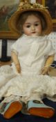 An early 20th century bisque headed doll, with composition body, open/sleep eyes and open mouth,