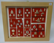 A framed collection of Military badges and buttons of various Regiments including Royal Artillery,