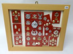 A framed collection of Military badges and buttons of various Regiments including Royal Hussars,