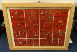 A framed collection of Military badges and buttons of various regiments including Reme Royal Signals