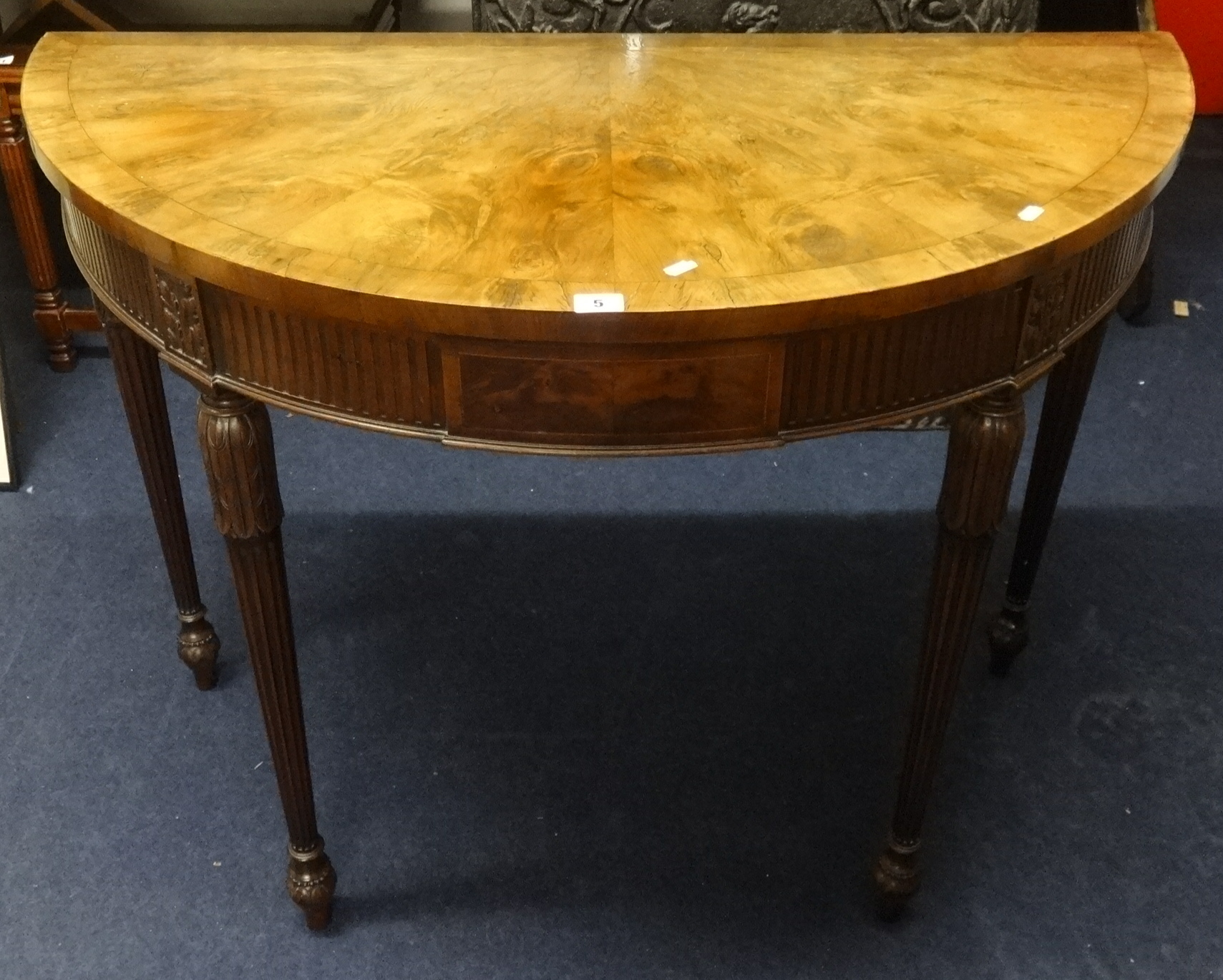 A reproduction mahogany half moon hall table on fluted legs, width 106cm.