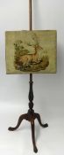A mahogany tripod pole screen with tapestry Stag decoration.