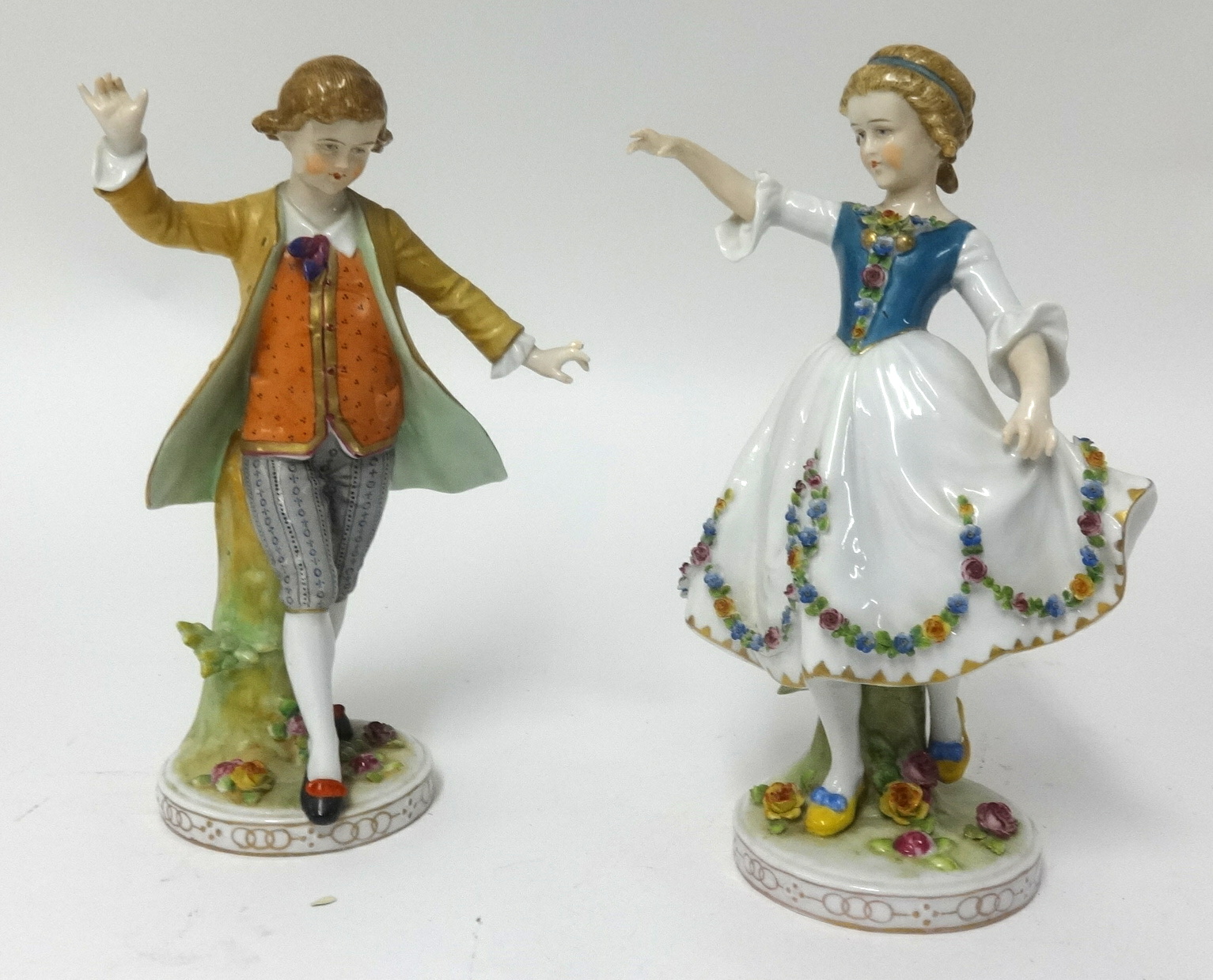 An early 20th Century pair of porcelain figures of a girl and her companion, approx height 23cm.