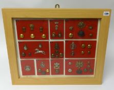 A framed collection of Military badges and buttons, frame size 48cm x 58cm (approx 45).