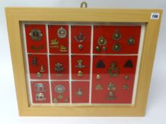A framed collection of Military badges and buttons of various Regiments including Royal Marines