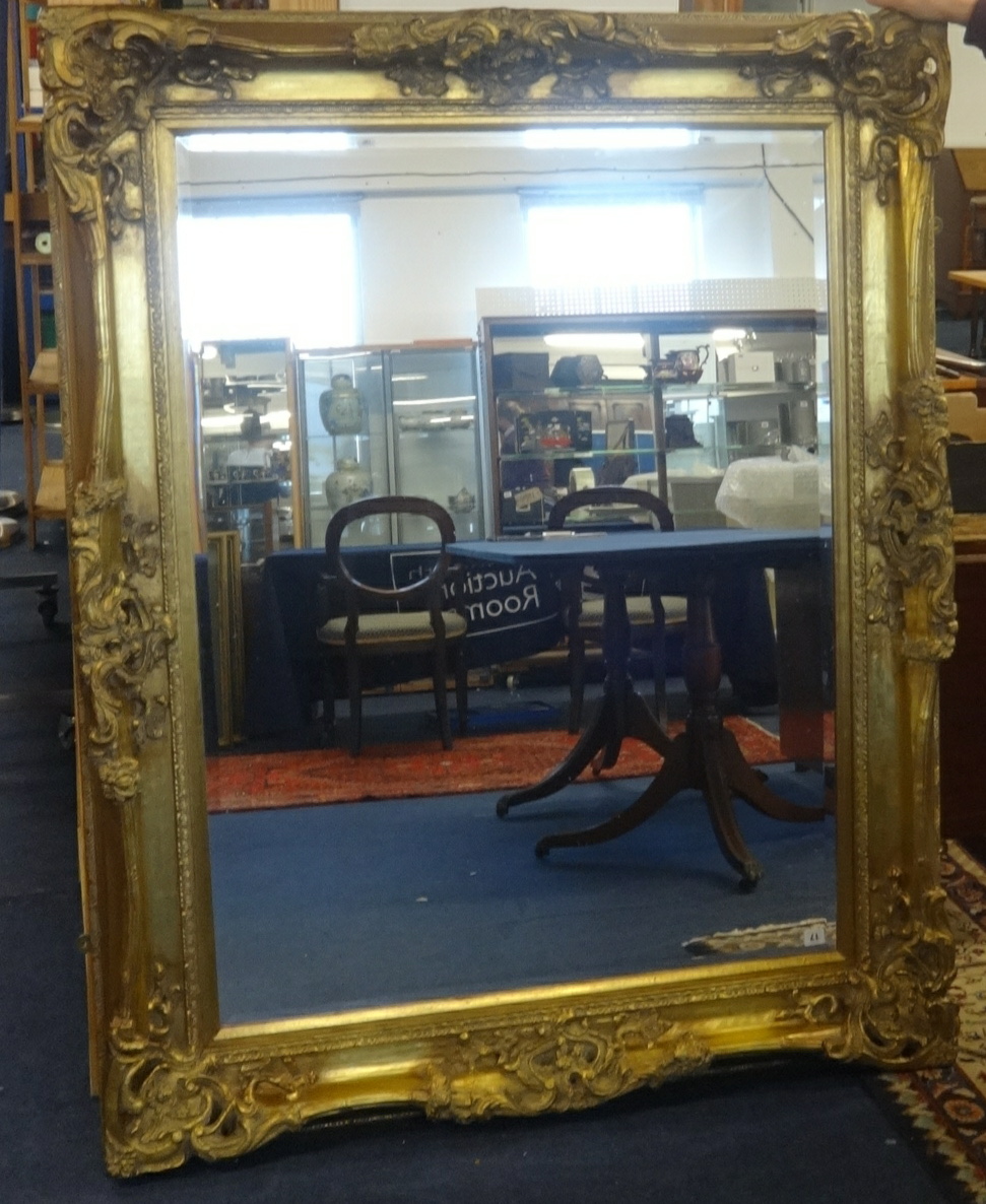 A large reproduction gilt framed mirror with bevelled plate, overall size approx 154cm x 123cm.