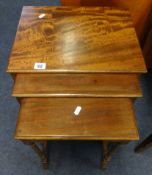 A small mahogany nest of tables, with retailers label 'James Reeve Ltd'.