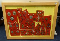 A framed collection of Military badges and buttons of various regiments including Royal Marines,