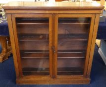 A late Victorian walnut two door glazed bookcase, width 107cm, height 108cm.