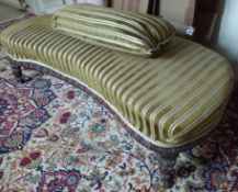 A Victorian mahogany framed and upholstered seat of kidney shape with brass castors.