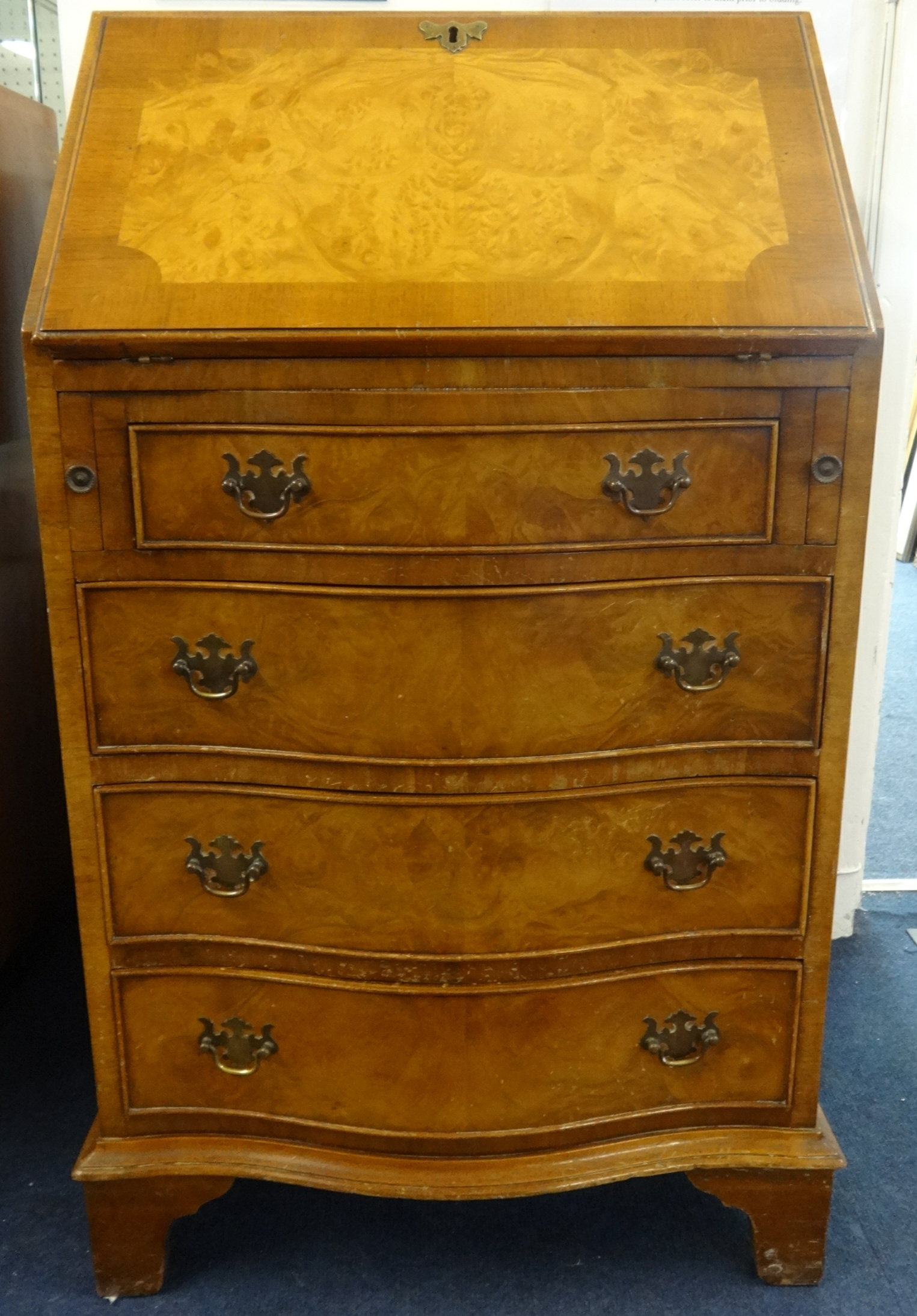 A reproduction burr walnut bureau, fitted with four serpentine drawers, width 54cm.