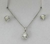 A 18ct white gold and diamond set pendant and a matching pair of earrings.
