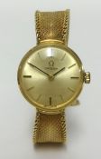 Omega, a ladies 9ct gold wristwatch, with baton numerals and Milanese bracelet, total weight 23gms.