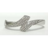 A fine 18ct white gold bangle set with pave with round cut diamonds of stylist serpent head form,