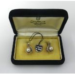 Mikimoto, a pair of pearl and silver earrings of leaf design in original box, Hong Kong.