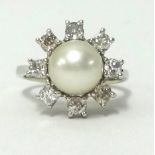 An 18ct white gold pearl and diamond set cluster ring, finger size J.