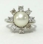An 18ct white gold pearl and diamond set cluster ring, finger size J.