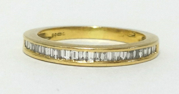 A 18ct half band eternity ring, set with baguette cut diamonds, finger size K/L.