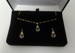 A 9ct amethyst and diamond pendant on fine gold chain and a matching pair of earrings en suite.