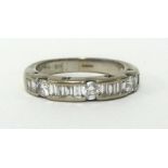 A 18ct white gold half band eternity ring, set with an arrangement of baguette and round cut