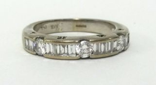 A 18ct white gold half band eternity ring, set with an arrangement of baguette and round cut