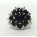 A 18ct white gold sapphire and diamond cluster ring, set with an arrangement of nine sapphires