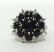 A 18ct white gold sapphire and diamond cluster ring, set with an arrangement of nine sapphires