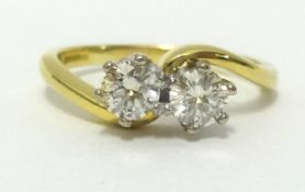 An 18ct diamond crossover ring set with two stones, finger size O.