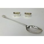 A pair of napkin rings (French) and silver plated serving spoon.