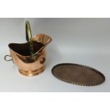 A Copper coal helmet with original receipt 1952, together with a hammered oval copper tray stamped