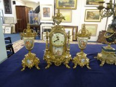 A reproduction French three piece clock garniture set, decorated in gilt metal work and porcelain,