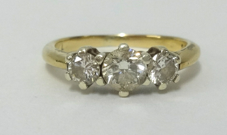 A 9ct gold and three stone diamond ring, total diamond weight approx 0.76cts together with 2007