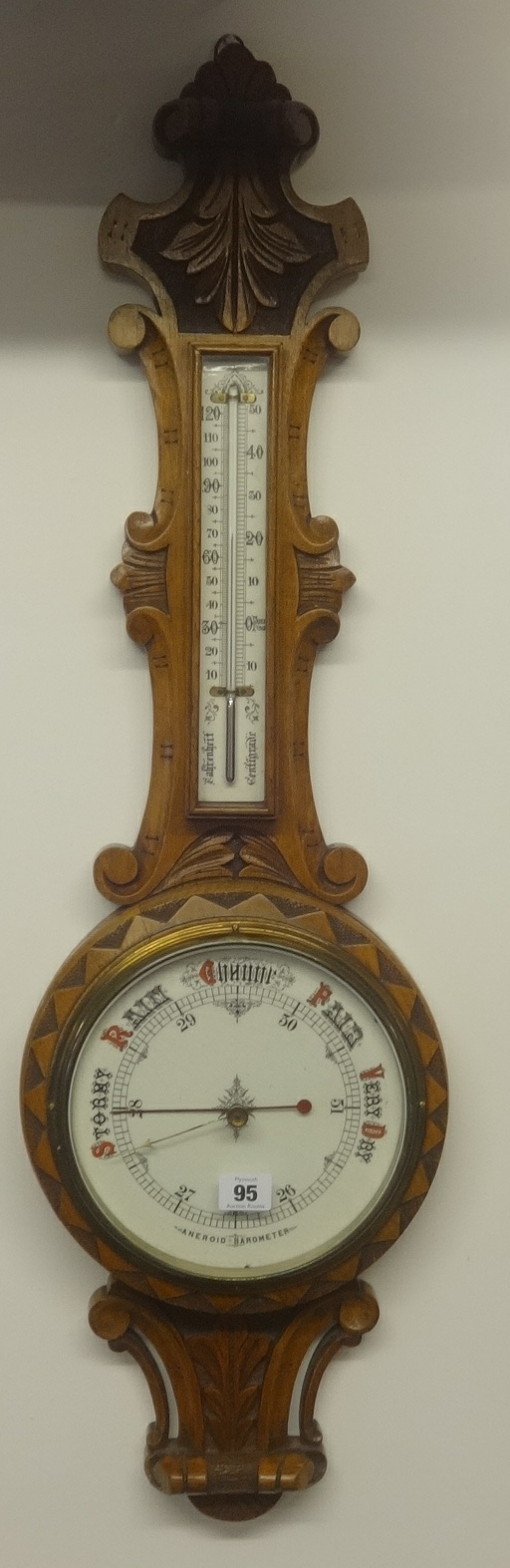 Early 20th Century aneroid barometer and thermometer in carved oak case.