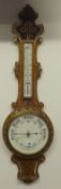 Early 20th Century aneroid barometer and thermometer in carved oak case.