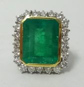 A large and impressive emerald and diamond cluster ring, the rectangular emerald approx 14mm x 10mm,