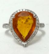 A 14k white gold and diamond ring set with a pear cut orange sapphire approx 3.90ct, diamonds approx