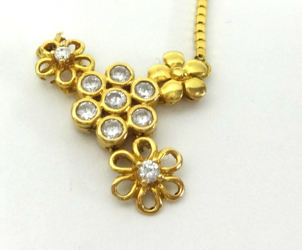 A diamond set pendant of flower design in yellow metal, the chain stamped 750. (damaged)