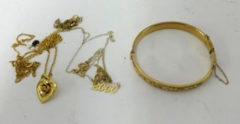 A 9ct gold bangle, a yellow metal heart and flower pendant on fine chain and another gold necklace