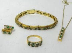 A suite of jewellery, comprising white sapphire and emerald stones, bracelet, ring, pendant and a