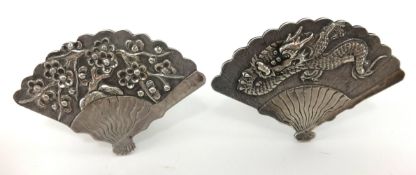 A pair of chinese silver fan shaped place setting holders decorated with a chinese dragon a fan,