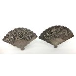 A pair of chinese silver fan shaped place setting holders decorated with a chinese dragon a fan,