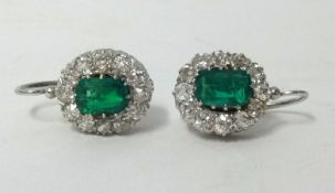 A good pair of emerald diamond cluster earrings set in white gold.