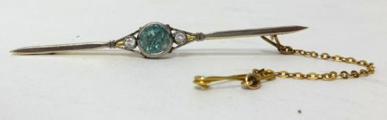 A yellow metal blue zircon set brooch.