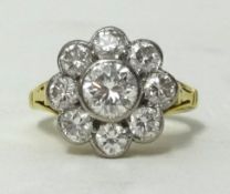 A fine diamond cluster ring in 18ct gold, consisting of eight diamonds surrounding a large centre
