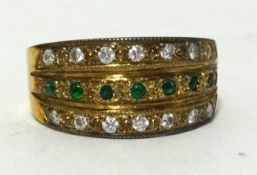 An emerald and diamond set three row band ring in yellow metal, approx 9.10gms, ring size J1/2